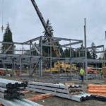 a crane is installing steel framing for a large building